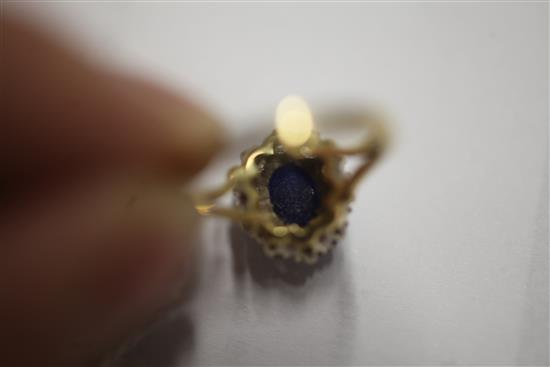 A cabochon sapphire and diamond cluster ring, size N.